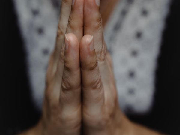 Close-up of a person's hands in a meditative mudra gesture.